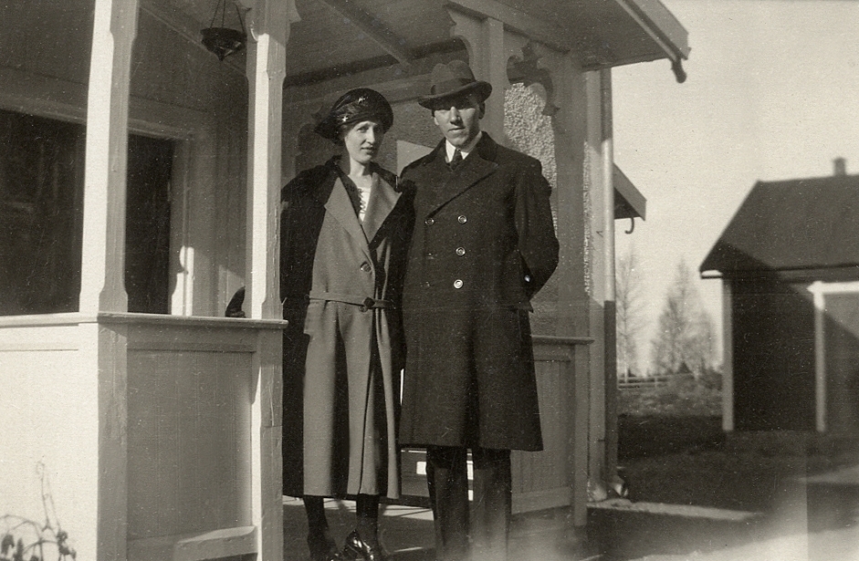 En kvinna och en man står vid en veranda.