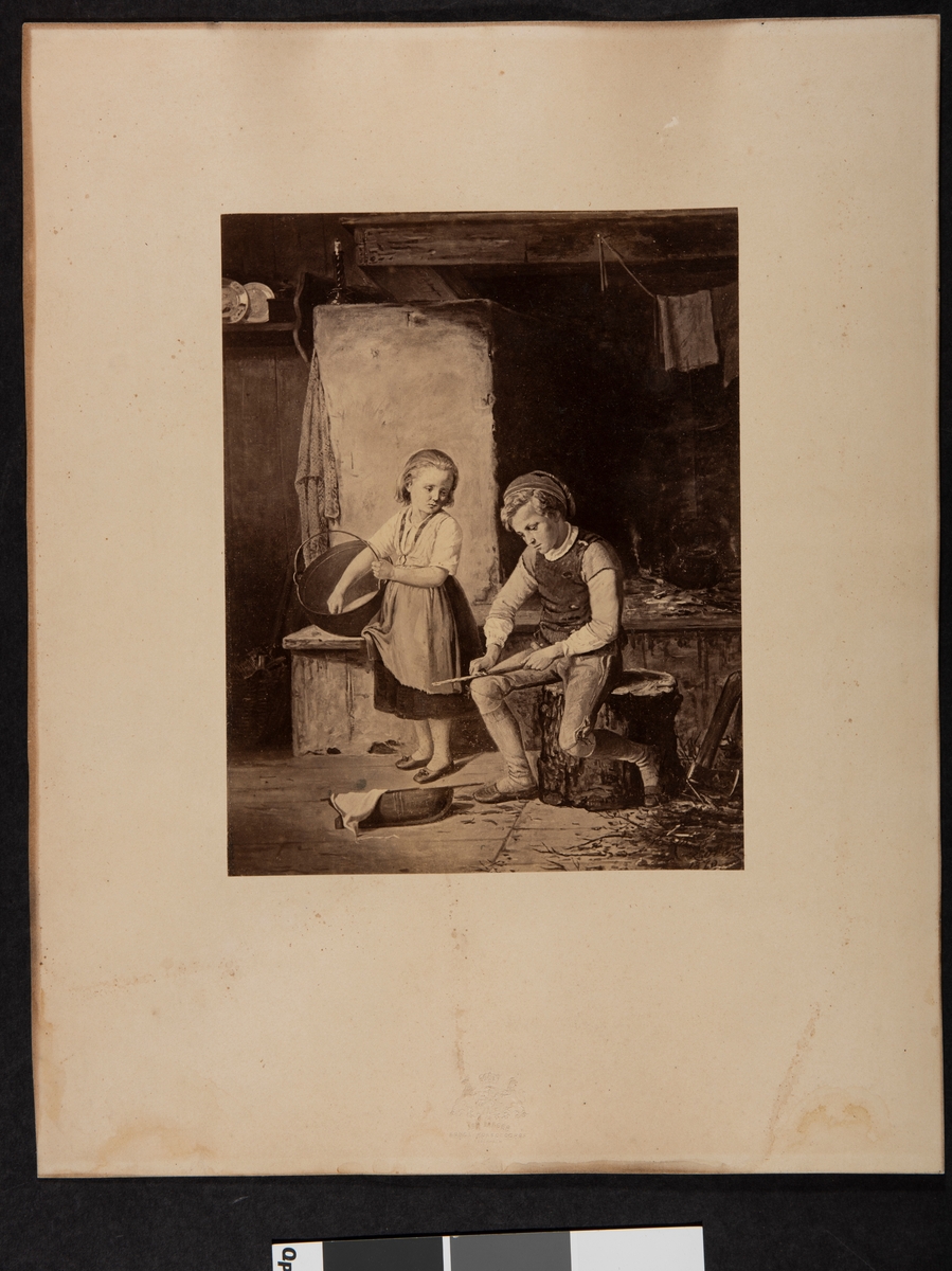 Foto av maleri i glass og ramme. Utført av kongl.hoffotograf Joh. Jaeger i Stockholm. Maleriet er av gutt og jente ved peis fra 1860. 