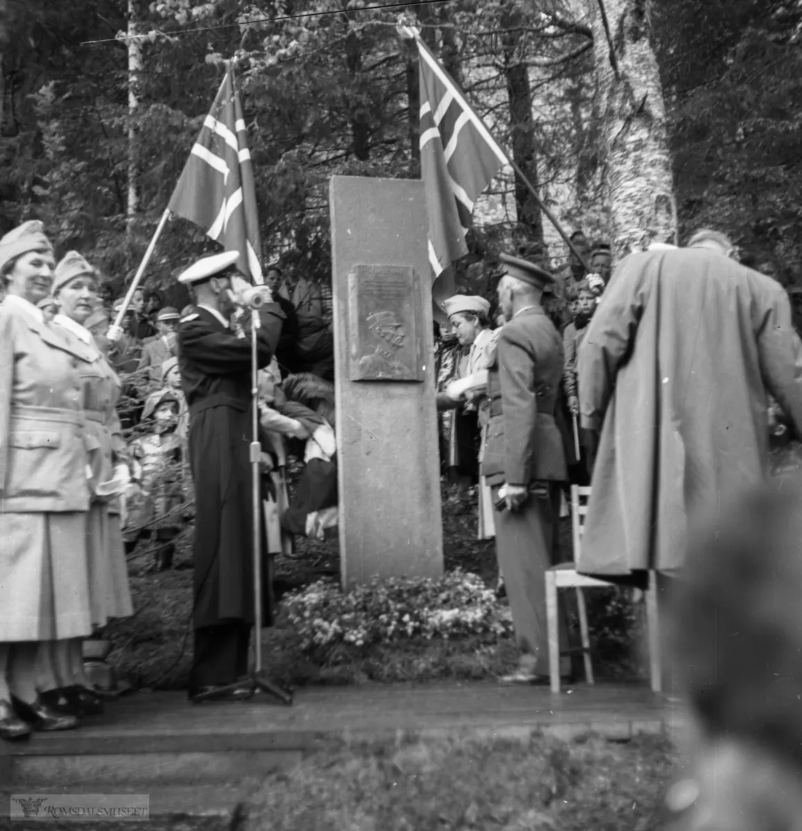 "Avdukingen av monumentet ved Kongebjørka i 1955. Med Kong Haakon, Kronsprins Olav, fylkesmann Oksvik, lottene osv."