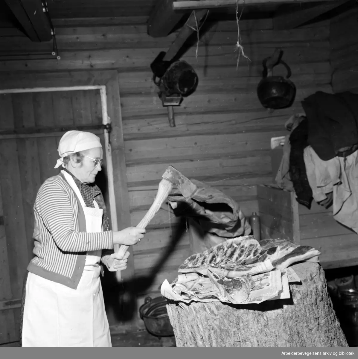 Juleforberedelser på Øvre Johnsrud gård i Lommedalen. Judith Johnsrud svinger øksa i stabburet. Desember 1958.