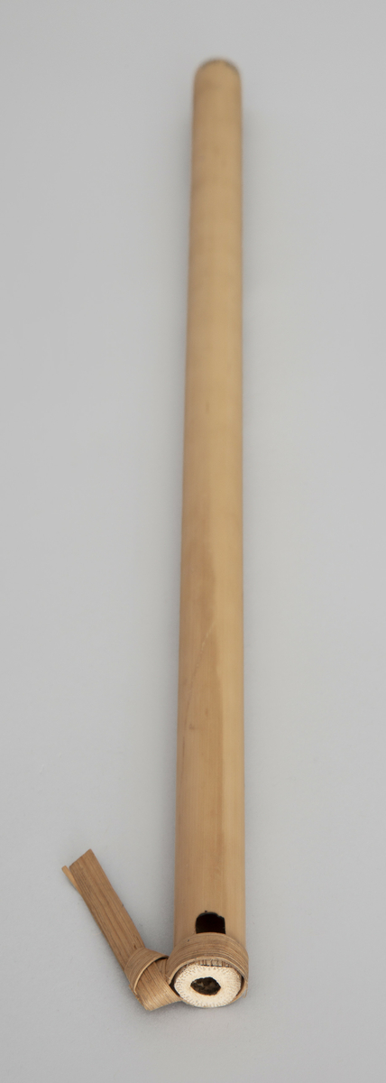 Spaltefløyte av bambus. Spalten dannes ved hjelp av en løs ring av tørket blad som festes rundt røret. Utvendig dekorert med enkel symmetrisk innbrent dekor.
6 fingerhull. Sylindrisk boring.