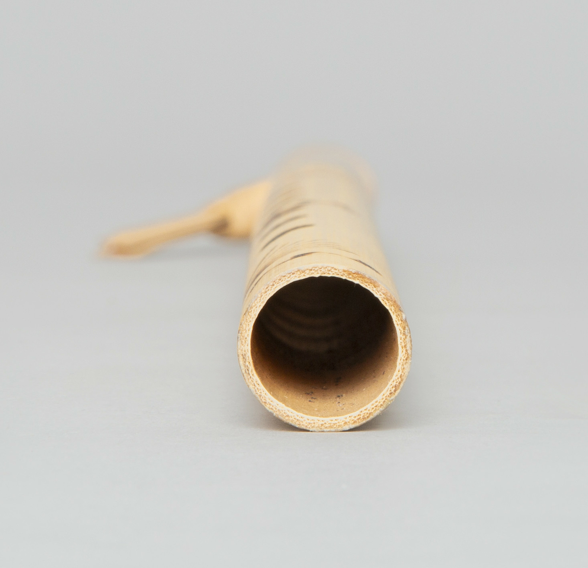 Spaltefløyte av bambus. Spalten dannes ved hjelp av en løs ring av tørket blad som festes rundt røret. Utvendig dekorert med enkel symmetrisk innbrent dekor.
6 fingerhull. Sylindrisk boring.