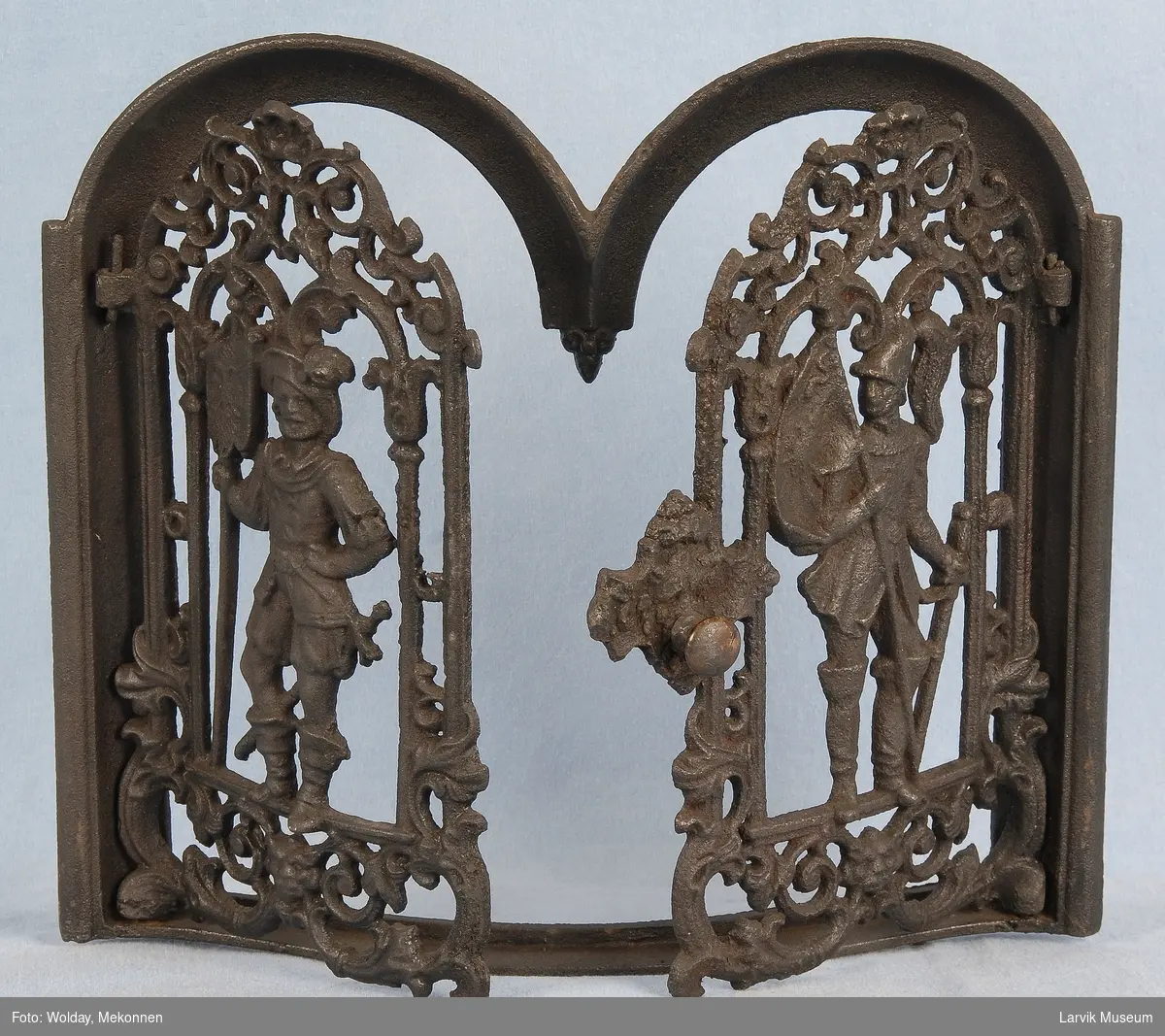 Dørene har gjennombrudt ornamentikk med en ridder midtstilt i en dbl. bueformet ramme