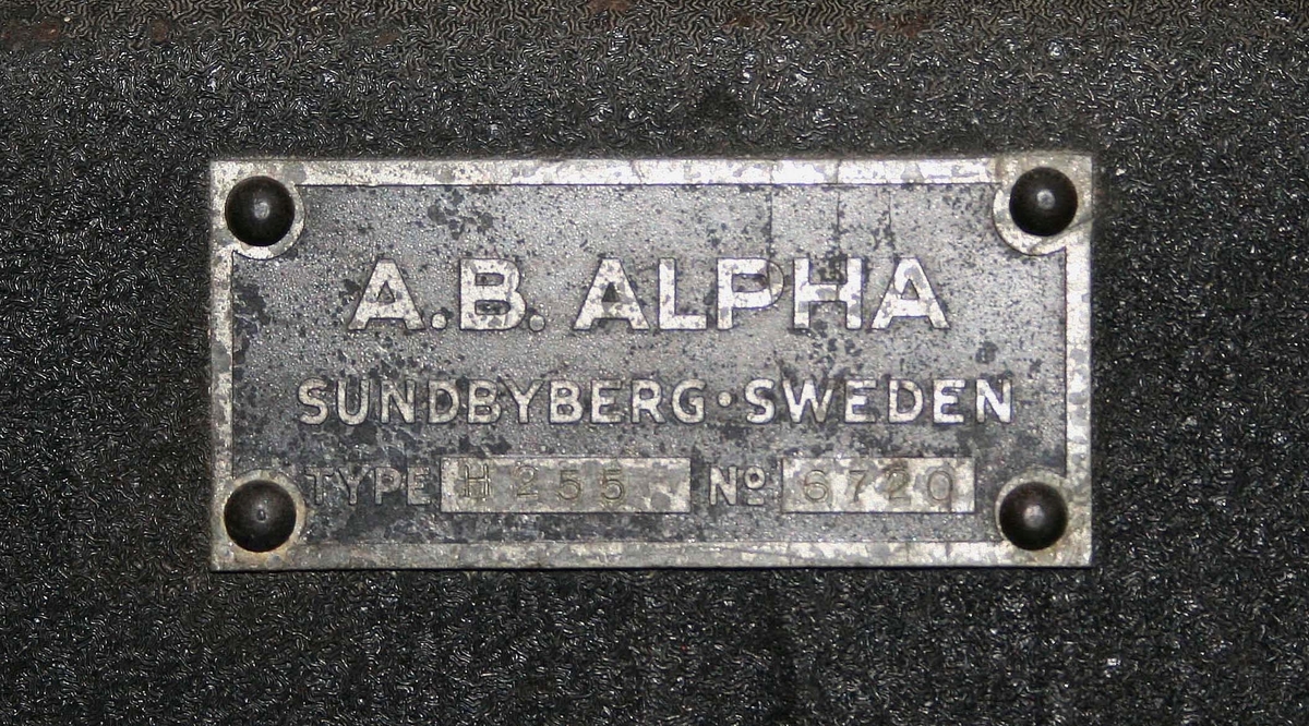 Studselasticitetsmätare i svartlackerat järn. Märkt:  Alpha AB Sundbyberg, Sweden, Type H 255 No 6720 (mäter i %). Proveniens Viskafors Gummifabrik AB, Viskafors.