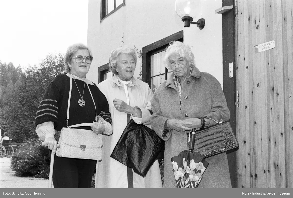 Det er pensjonisttur. Tre kvinner ved en av bygningene ved Blaafarveværket.