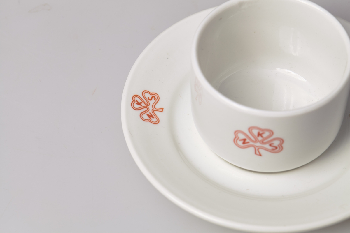 Kaffekopp med skål. Både kopp og skål har logoen til Norske kvinners sanitetsforening. Med tilhørende asjett, TM-16057. 