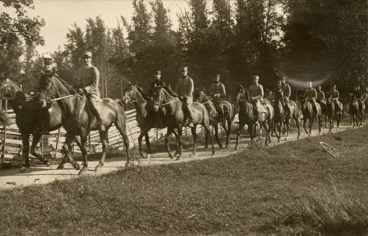 Soldater till häst på övningsplats.