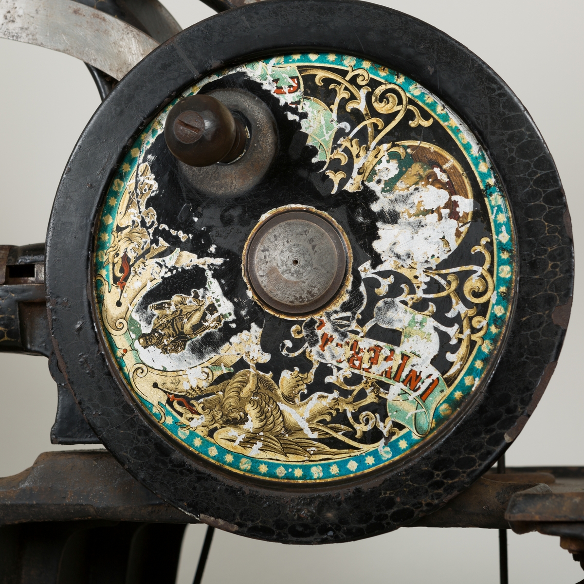 Manuell, pedaldrevet skomakermaskin, dekorert med en krone og to løver
