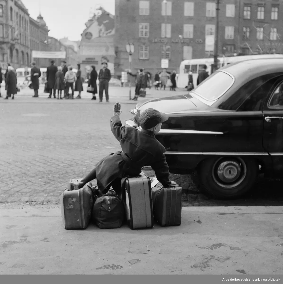 Venter på drosje. Liten gutt med kofferter utenfor Østbanehallen i Oslo. April 1958.