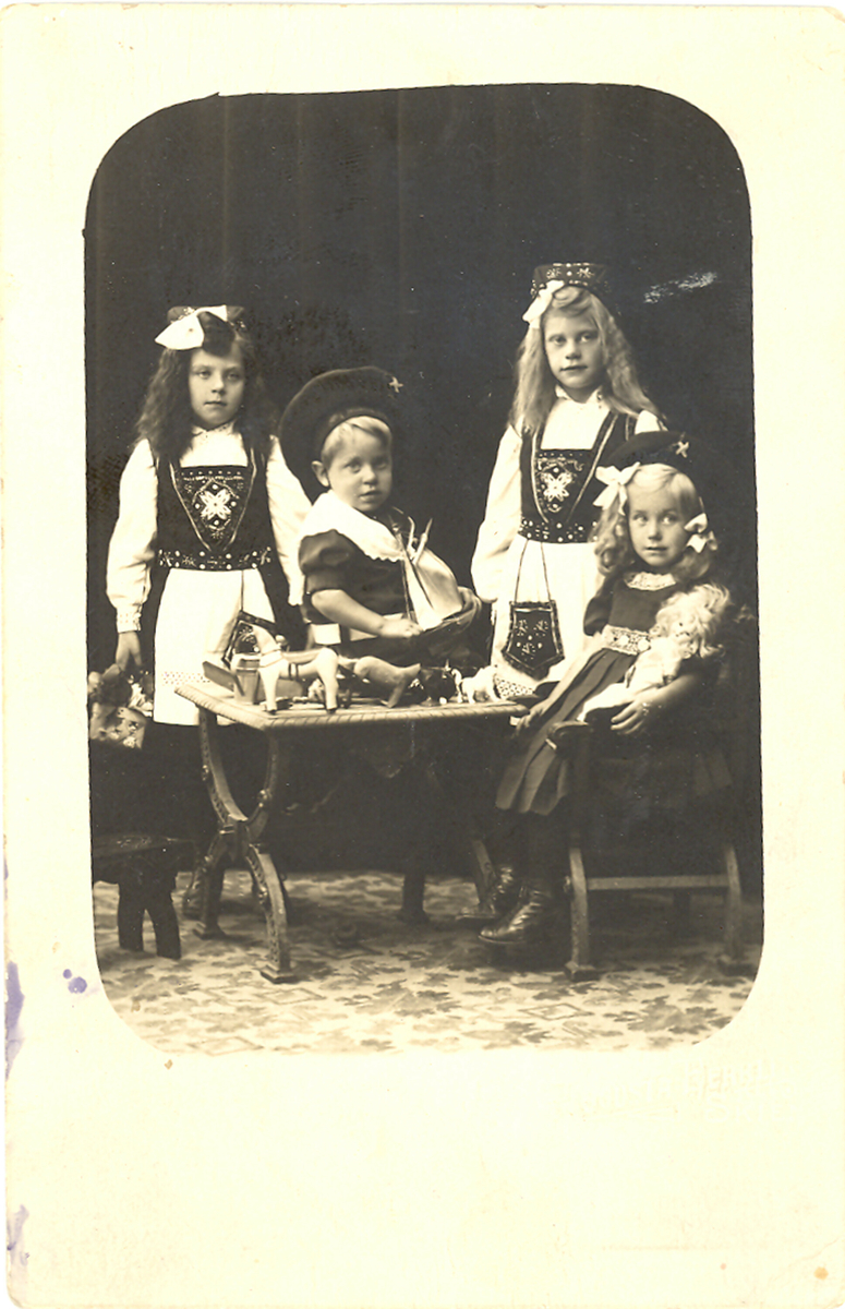 Tre jenter og ein gut kledd i finklede. Kitty, Gudrun, Hanna og Hans