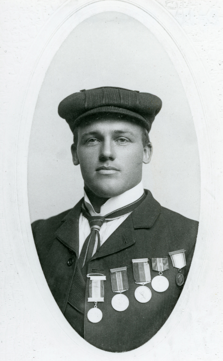 Ovalt brystbilde av Knut G. Helland i Amerika i 1906. Han har fem skimedaljer på brystet.