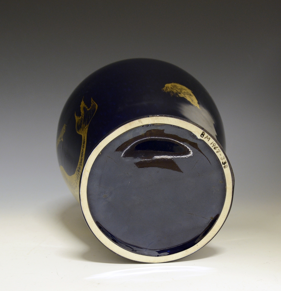 Prot: Stor vase av porselen. Dyp blå glasur. Dekor i gull: havfrue og fisk. Uten mrk. og sign. Form: Konrad Galaaen, dekor: Andor Hubay. Produsert 1954.