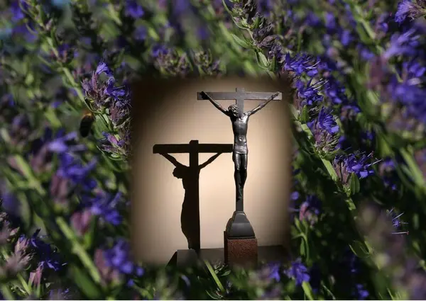 Statue av korsfestet Jesus på en bakgrunn av blå isop.. Foto/Photo