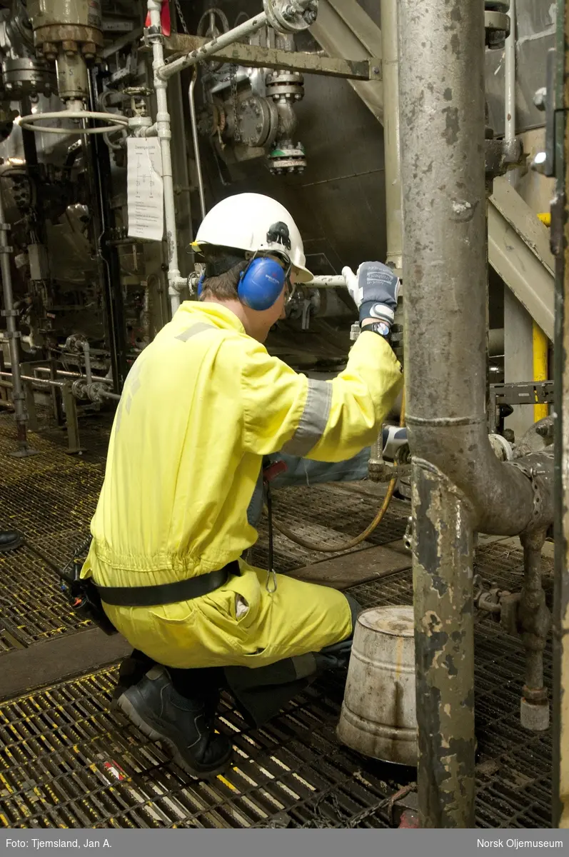 Teknikker i arbeid på Statfjord A.  Han sjekker, fjerner og tar prøver av oljeholdig  sand som følger med i produksjonsprosessen.