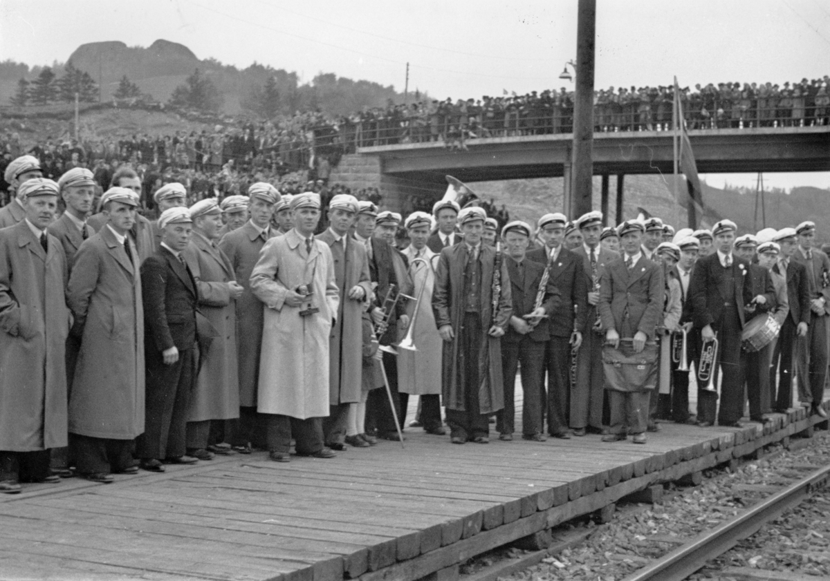 Jernbanestasjonen på Eie, 10. mai 1945. Musikkorps og sangere venter på toget med Grinifangene.