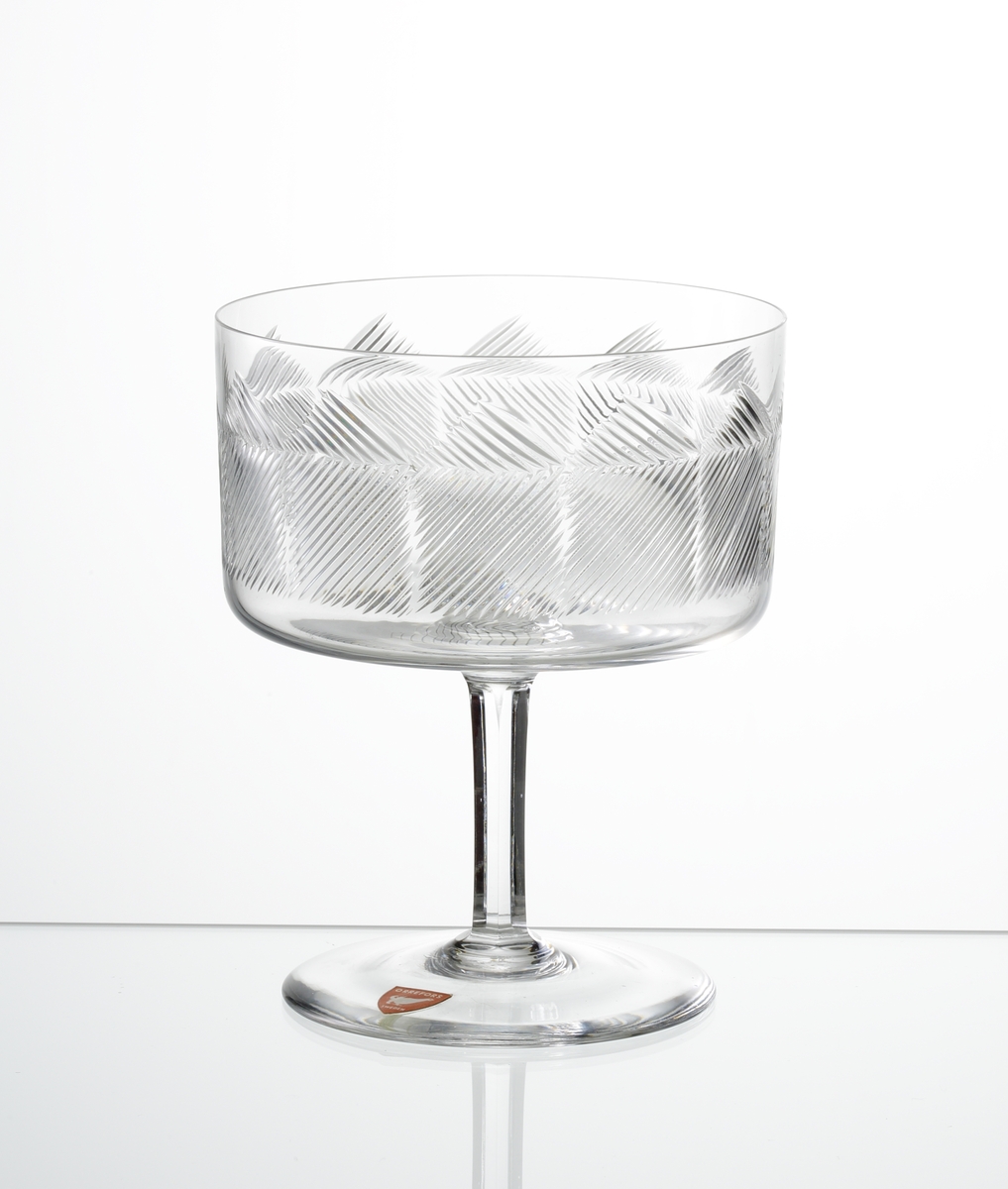 Design: Ingeborg Lundin.
Champagneskål, cylindrisk kupa med skärslipade diagonala linjer som skapar ett
geometriskt mönster. Fasettslipat ben och slät fot.