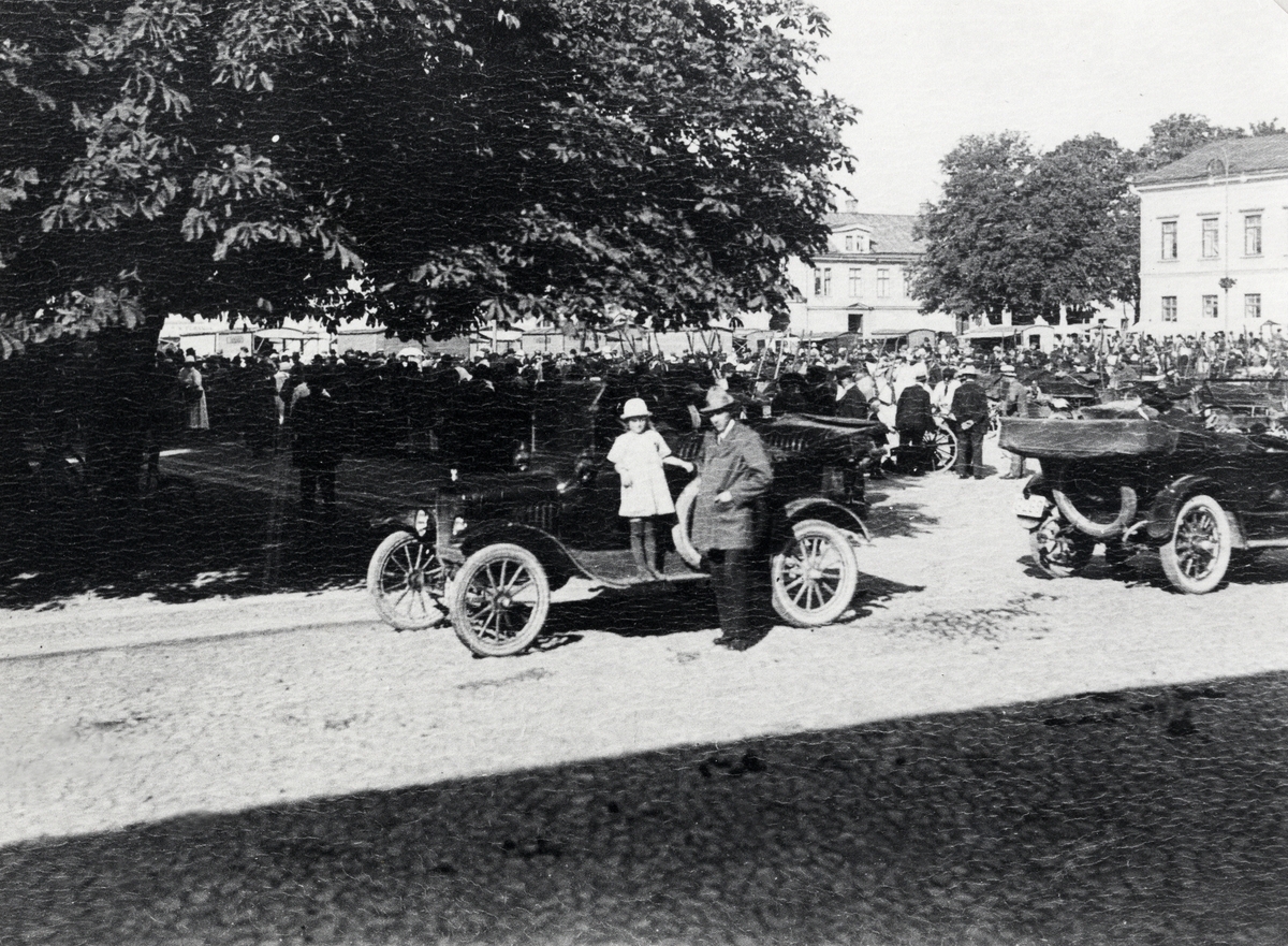 Några bilar har parkerat på Kronobergsgatan, i hörnet vid stadshotellet, den 10/9 1921. I bakgrunden ser 
man liv och rörelse på stortorget.
