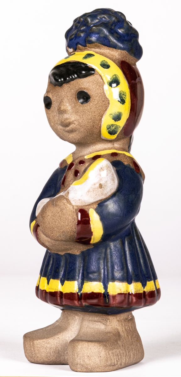 Figurin Lappflicka, formgiven av Dorothy Clough 1955 för Gefle Porslinsfabrik. Hör samman med figurinerna Lappojke och Lapphund.