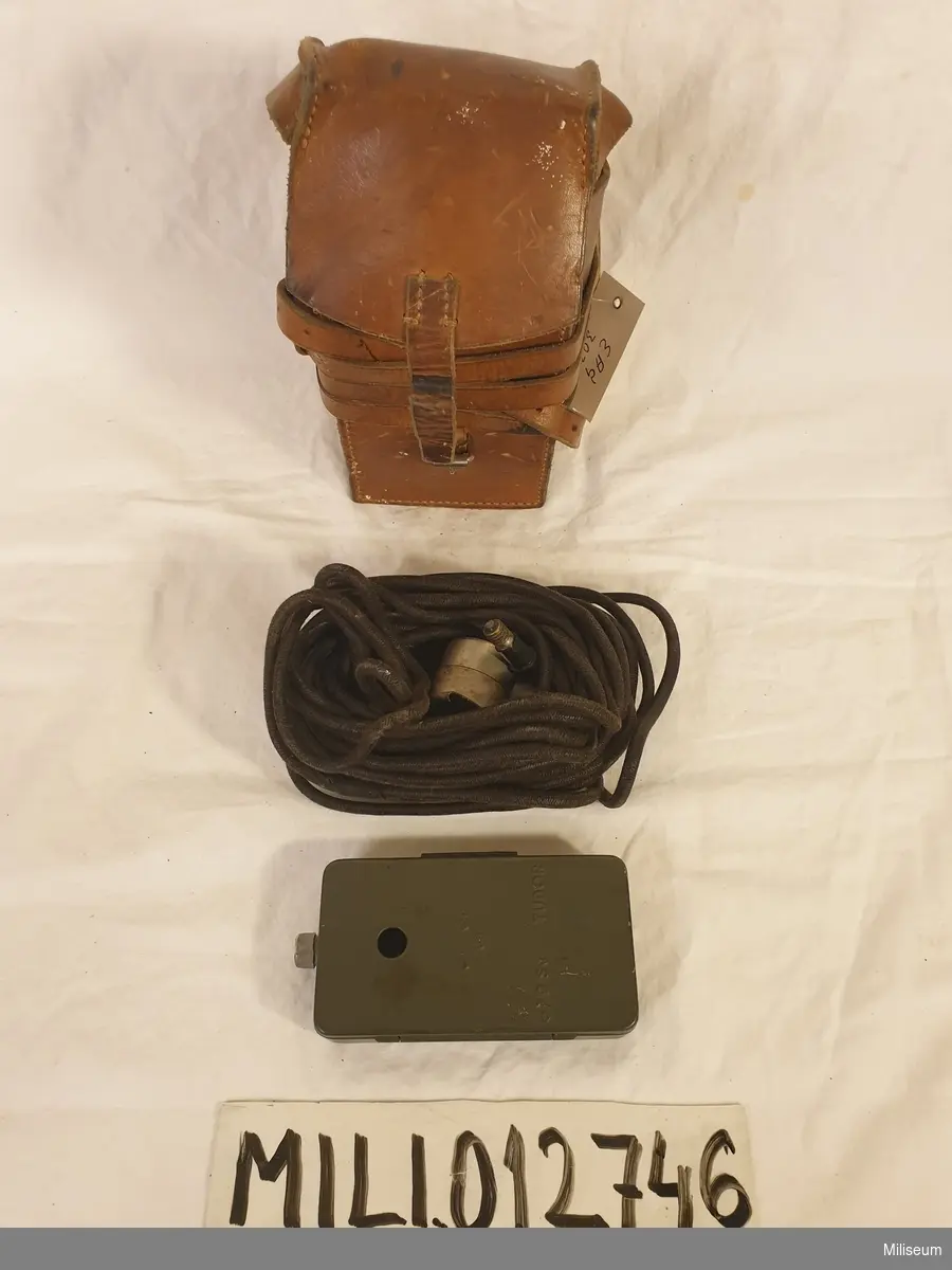 Läderväska med innehåll (belysningsanordning, batterihållare och sladd).