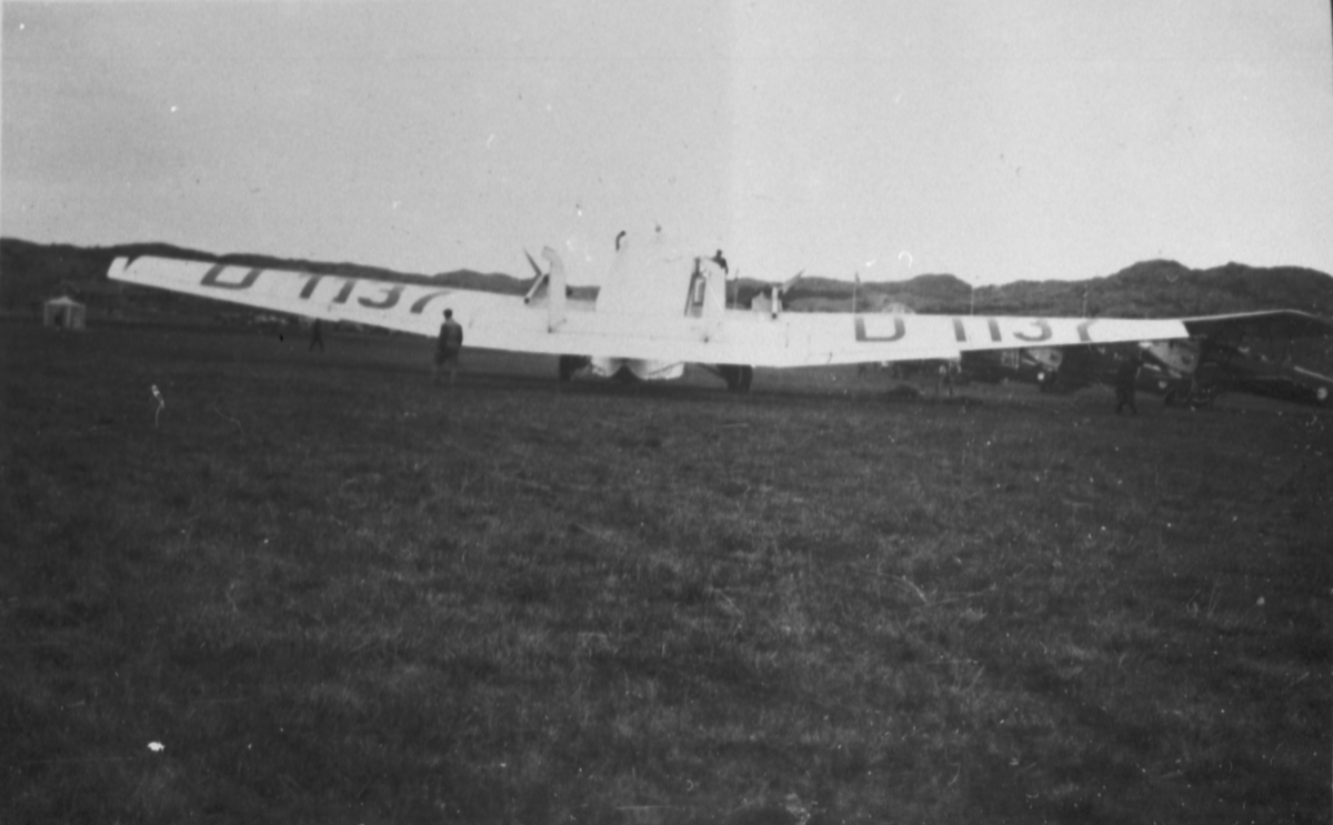 Civilt passagerarflygplan Junkers G 31ce D-1137 tillhörande Lufthansa på Torslanda flygplats vid Nordiska flygarmötet den 29 maj 1927. Vy bakifrån. Personer i rörelse kring flygplanet.
