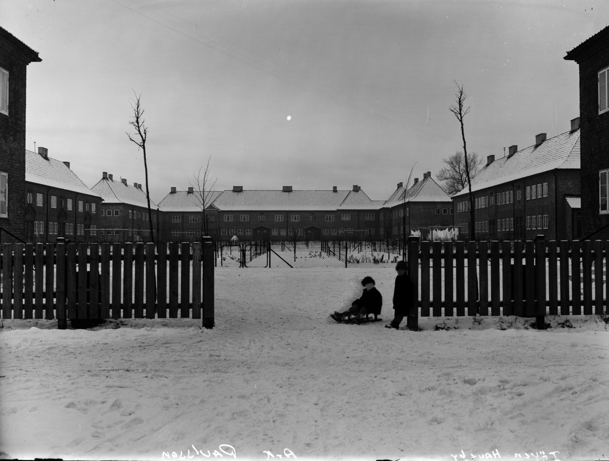 Mursteinsfasader på bygninger i Tøyen hageby, barn som leker i snøen.