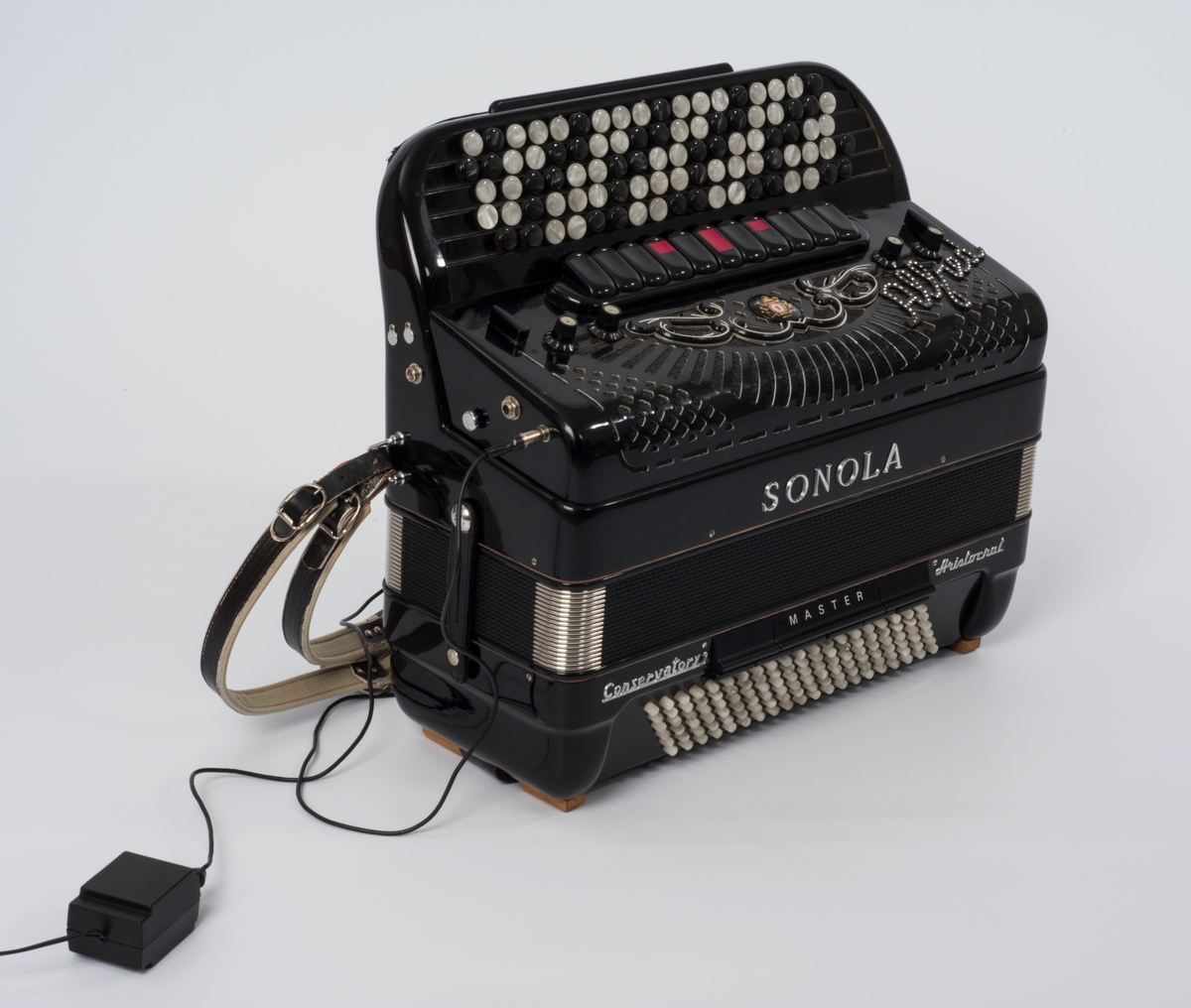 Elektrisk trekkspill med innebygd mikrofon og tilhørende koffert.