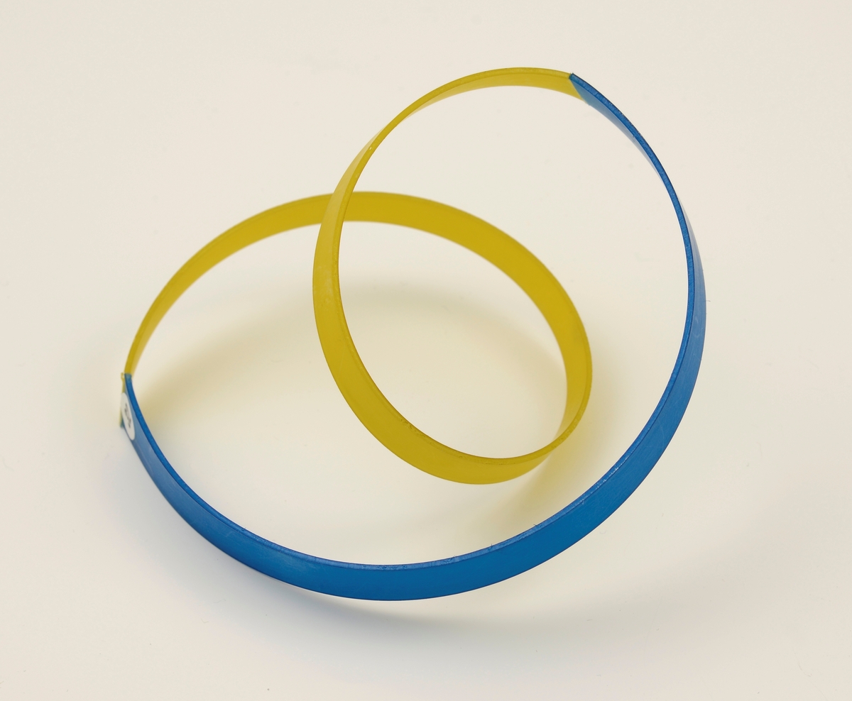 Armbånd laget av stive nylonbånd som er cirka 1 cm brede. Til en blå bue er det festet et gult tvunnet bånd.