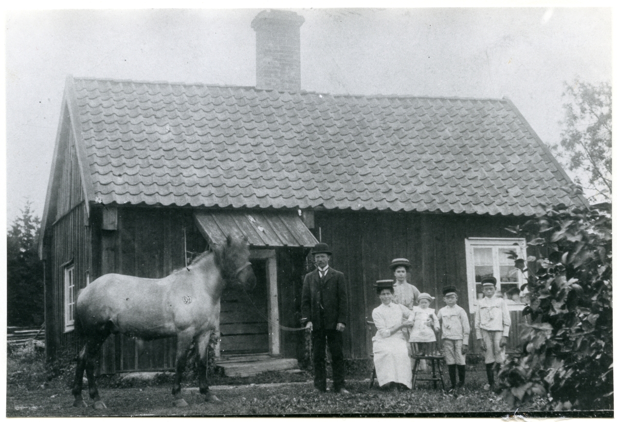 Ängsö sn, Västerås kn, Ektorpet.
Familj framför bostad, början 1900-talet.
