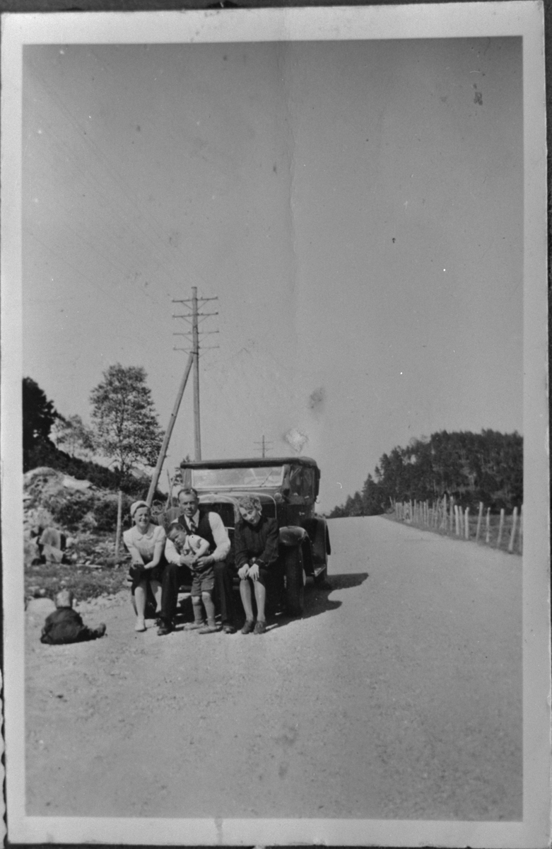 På tur ved Fikse i Ølen, ca. 1940. Bilen er ein Chevrolet 1931. Frå venstre: Anne Haugland, Jørgen H. Haugland, Harald Haugland (på fanget til Jørgen) og Marie Aarro.