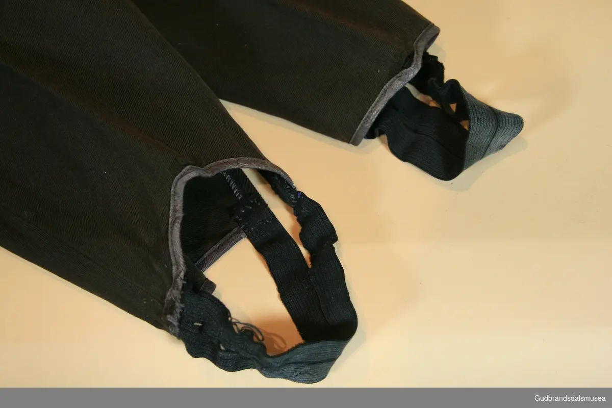 Skreddersydd langbukse med to lommer. Strikk nederst til feste av sko.