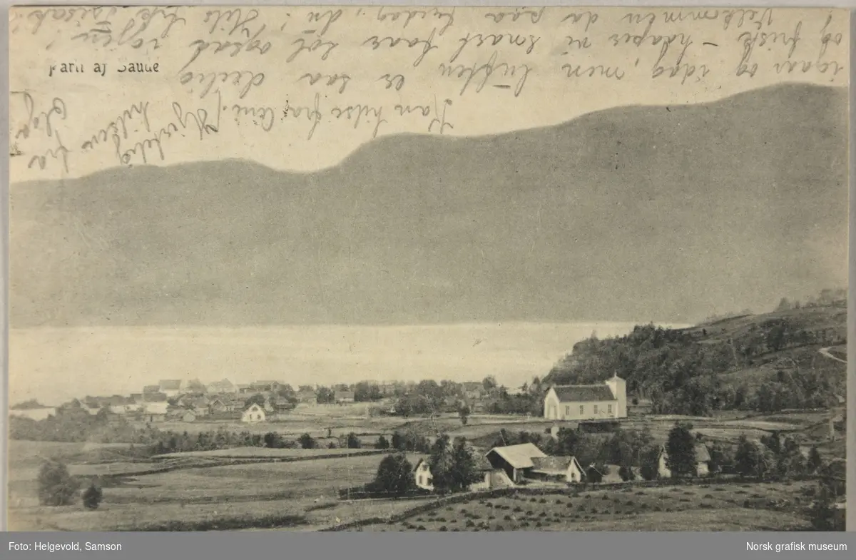 Postkort med bilde fra Sauda. Kirka og noen gårder ligger øverst i bygda, med flere hus ned mot fjorden.