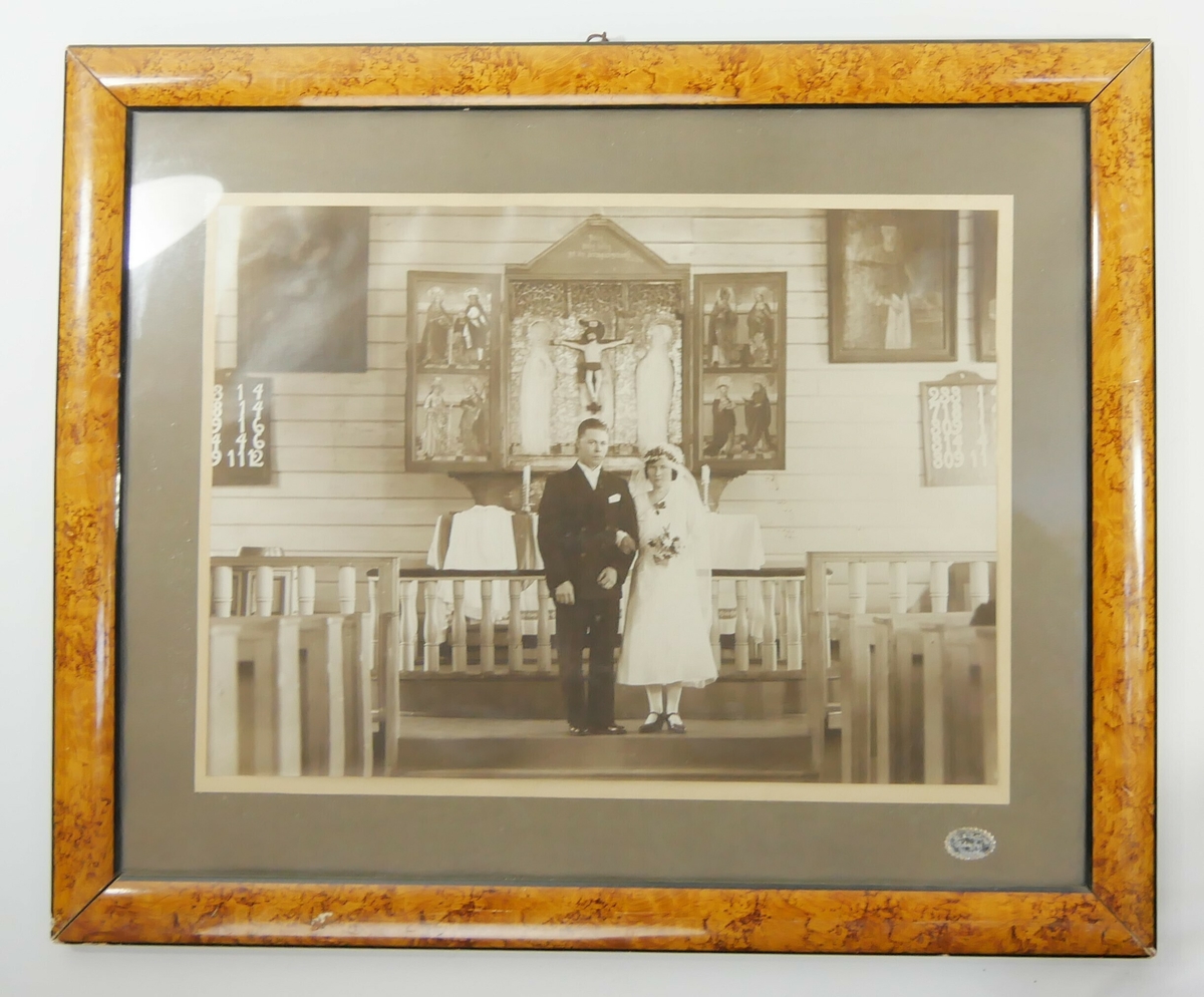 Et brudepar foran en altertavle i en kirke. 