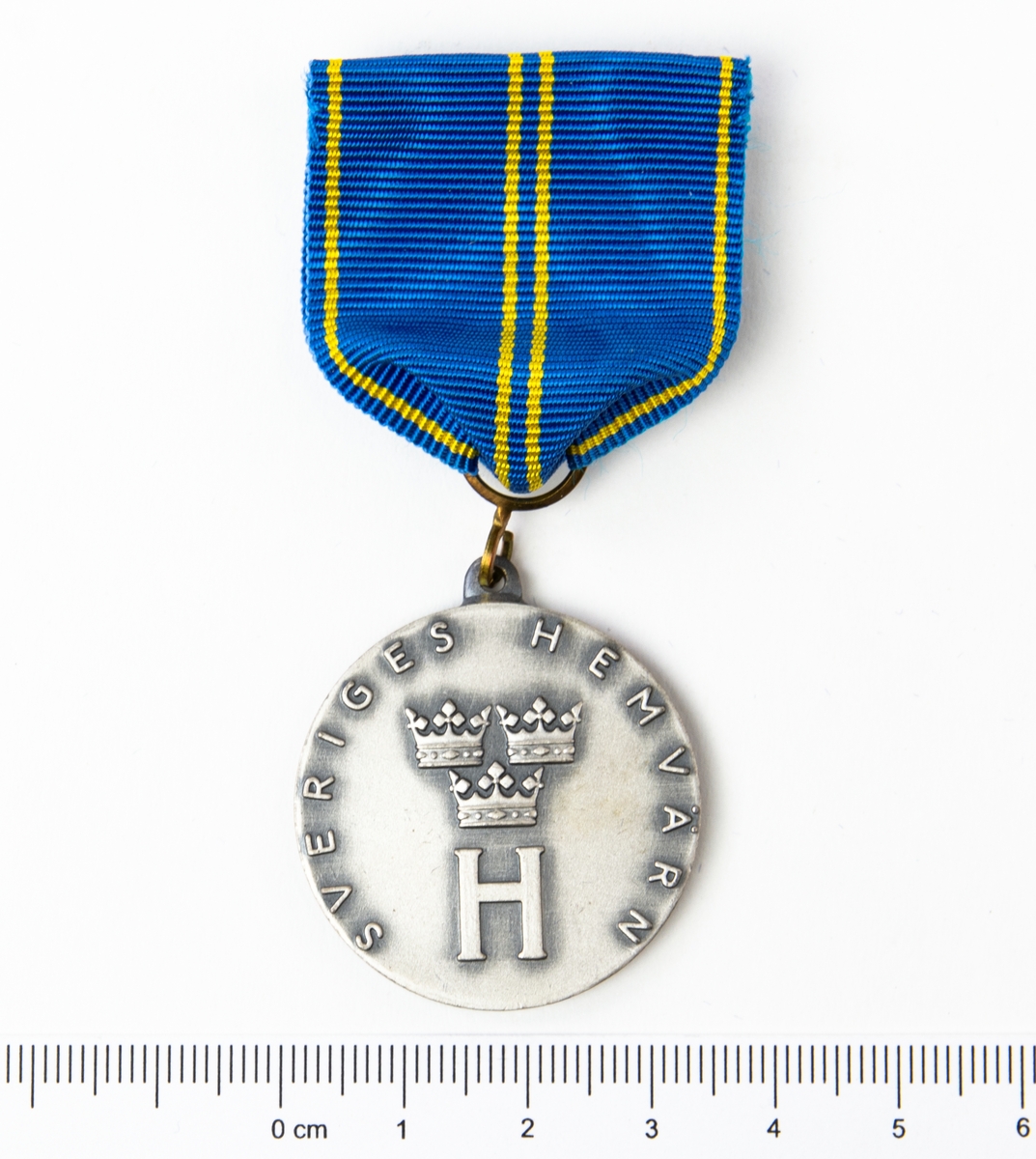 Framsida: Tre kronor med ett stort H under samt text Sveriges Hemvärn. Baksida: Flygvapnets emlem samt text Flygvapnets driftvärn, För förtjänster om hemvärnet.