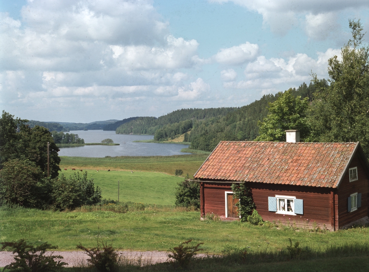 Vy mot sjön Båtsjön från höjden vid Gärdserums kyrkan. Stugan till höger är socknens tidigare fattighus.