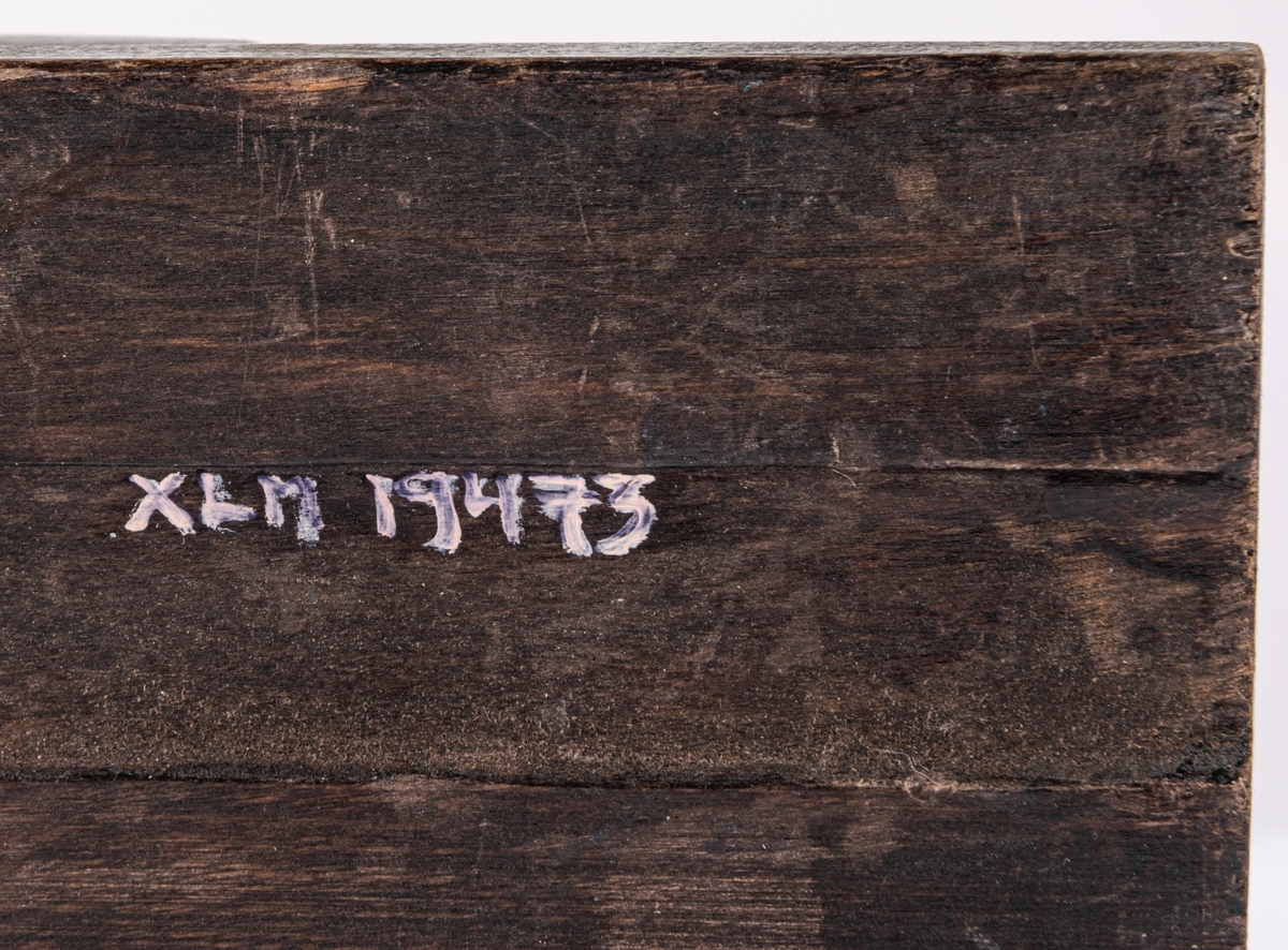 Acc.kat: Skidbindningsprov. Vit metallegering på underlag av mörkbrunfärgat trä. På ovasidan Elof Malmbergs firmamärke i matell. Rund metallkantad etikett med skriften "2001 M   N. 7/75" Märke på metalldelen "HOBBY".