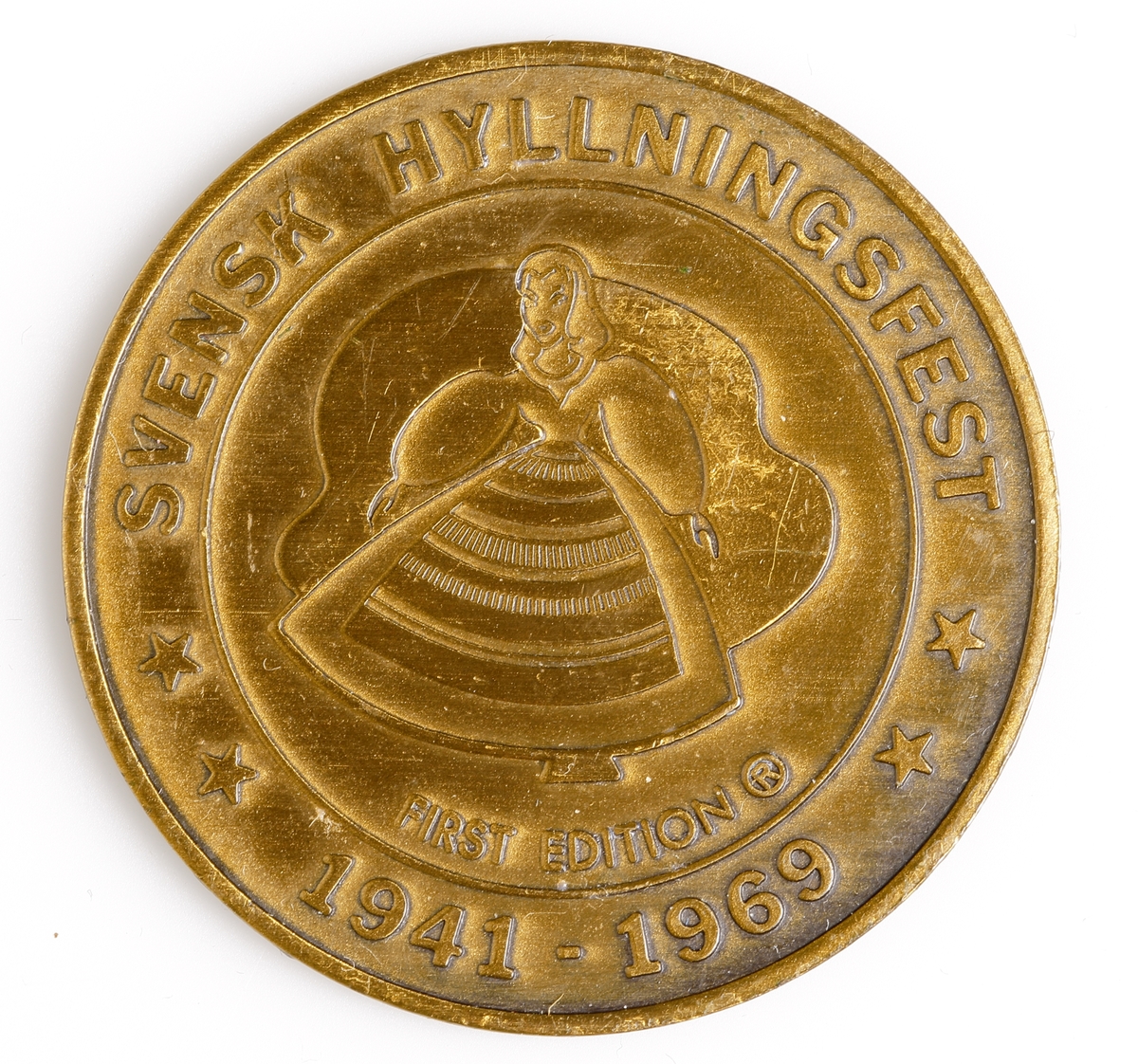 Medalj i mässing med en dalahäst avbildad på åtsidan, detta tillsammans med texten "LINDSBORG, KANSAS 1869 CENTENNIAL 1969". Frånsidan har en stiliserad kvinna i folkdräkt avbildad centralt på medaljen omgärdad med texten "SVENSK HYLLNINGSFEST 1947-1969 FIRST EDITION". Denna medalj utgavs vid staten Kansas hundraårsjubileum 1969.
