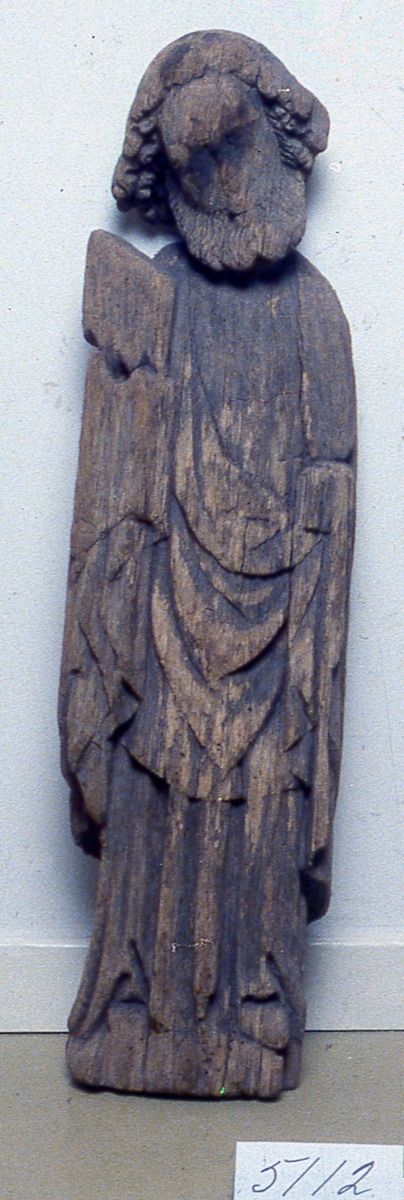 Skulptur av ek, föreställer Johannes, evangelisten (?). Huvudet med skägg och hår fint arbetat, är böjt åt höger. Bär en bok i höger hand. Manteln faller i mjuka veck. Starkt vittrad, del av sockel och höger sko borta. Huvudets hållning gör att man eventuellt kan förmoda att skulpturen hört till en kalvariegrupp (triumfkruxifix med sörjande Maria och Johannes). Har funnits i Grovare kyrka som revs 1873.