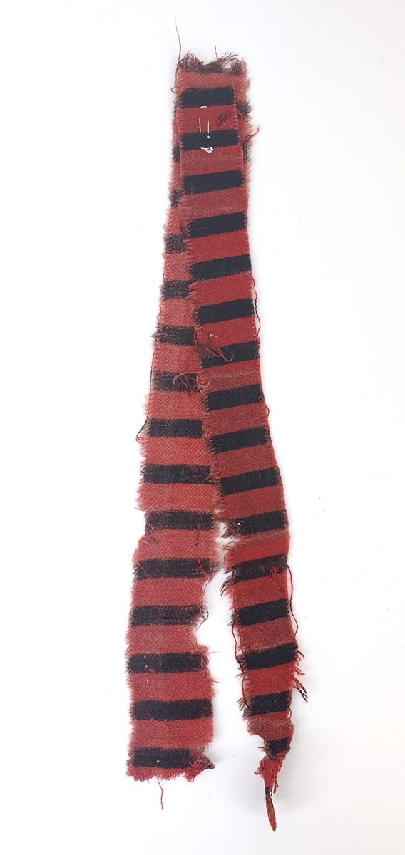 2 remsor, den ena är av oanvänt tyg och har stadkant. Den andra är väl använt och tyget är uttänjt.
Långrandig kypert med varpeffekt, bomull. Tryckta svarta ränder 0,5 cm på röd botten 1 cm.