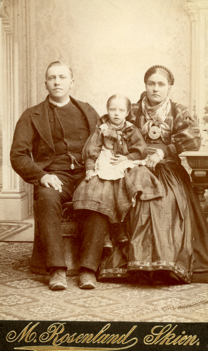 Familieportrett av mor, far og eitt barn