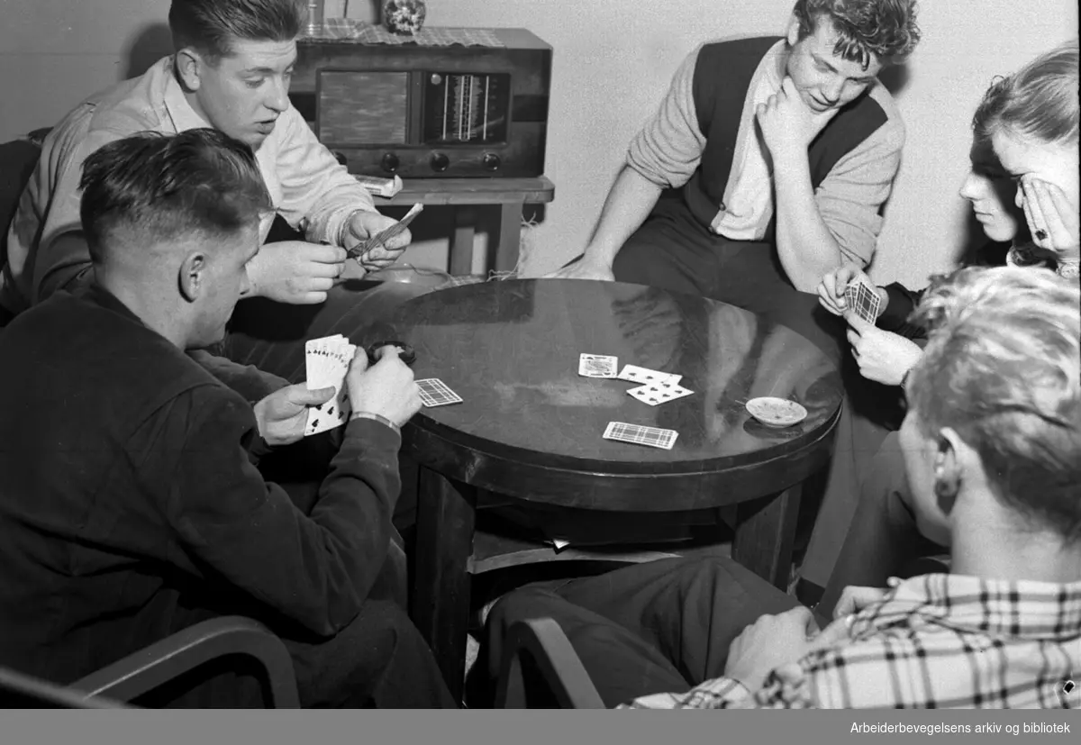 Ungdom spiller kort. Medlemmer av Sagene og Ila AUL på sitt nye hobbyrom. Desember 1953.
