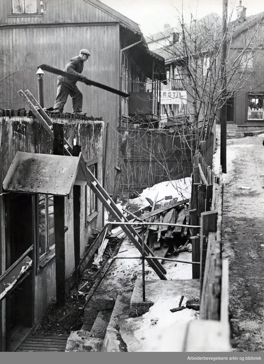 Riving av trehusbebyggelse i Hølandsgata på Kampen, Mars 1950. Saneringen ble startet for å gi plass til Jordal Amfi, som stod ferdig i 1951..