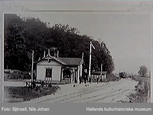 "Järnvägsstation. Stationsbyggnad vid Sundholmen. Sundholmen var järnvägs- och poststation längs järnvägssträckan Varberg-Borås i Marks härad, Horreds socken c:a 3 mil från Varberg. I Sundholmen fanns även gästgivaregård med skjutshållning. Första järnvägsförbindelsen Varberg-Borås invigdes 1880. Fotot från 1881-1885. Bildens beteckning ""Sundholmen"". Se originalbilden VMA11631.  Uppgifter om fotografen se Museets i Varberg årsbok, 1989."