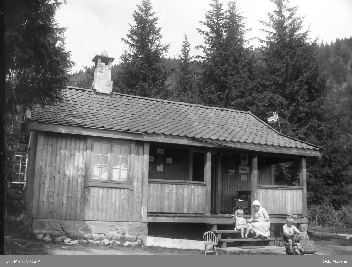 hytte Bloksberg, kvinne, jente, gutt, trehjulsykkel, flagg, skog
