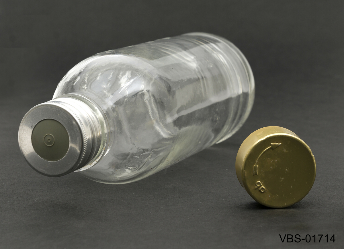 Glassflaske som måleglass (100 til 500 ml) med to lokk i metall og en gummi propp.
Sylindrisk måleglass som smalner i øvre del. 
Lokket er gylt og virker ved trykk. Den indreskrulokk er laget av aluminium og den sentrale delen er perforert. En tredje gummipropp forsegler innholdet i flasken.
Målingene på flasken er trykt for å brukes i begge retninger.