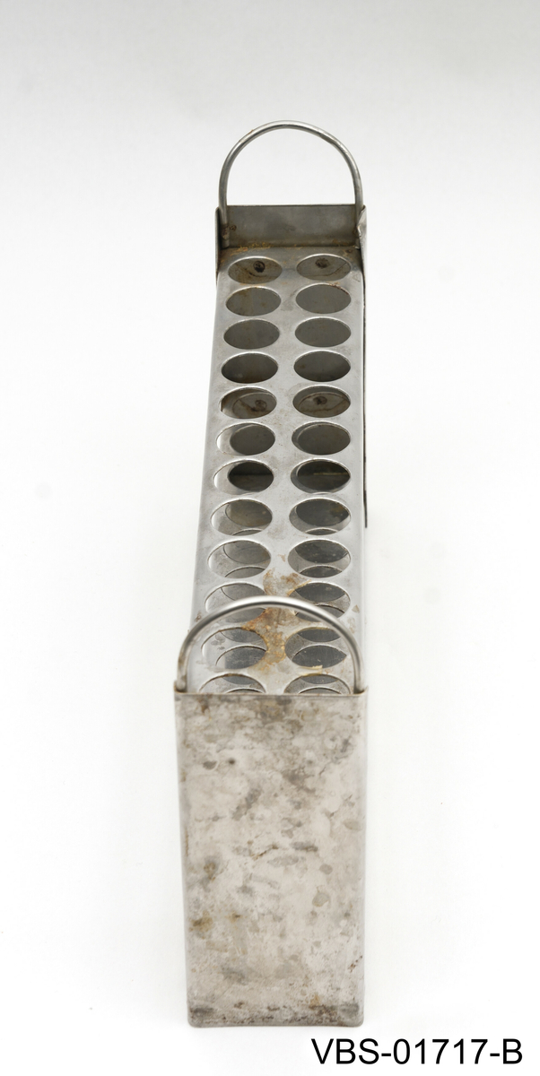 Aluminiums eske med, uten lokk, og to håndtak. Den inneholder et metallstativ med flere reagensrørholder eller glassrør.
Aluminiums eske (A), stål stativ (B) og glassrør (C) på bilder.

Glassrør settet består av: 
2 hvite glass prøverør (13x2cm diameter). Brukte.
3 grønne glassrør (20x1,5 cm diameter). Brukte.
5 hvite glassrør (28x1,5 cm diameter). Brukte.
3 hvite glassrør (50x1,5 cm diameter). Brukte.
4 nye hvite glassrør (28x1,5 cm diameter). Brukte.
