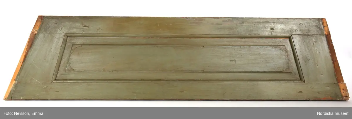 Panel, 3 st, av furu, målad i grågrön oljefärg, omkring 1740. Fyllningar med upphöjt mittparti.

Anm: Partiellt färgbortfall och skador. Panelerna har varit placerade ovanför fönstren i nischerna. 
/Anna Arfvidsson Womack 2021-07-16
