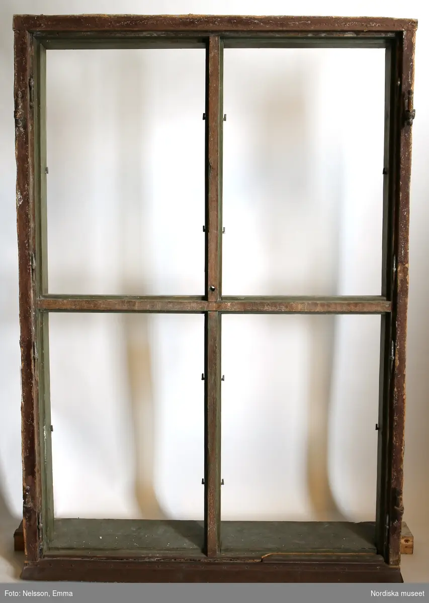 Fönster med karm, fyra fönsterbågar med vardera sex glasrutor, omkring 1740. Utvändigt målat brunt, invändigt grågrön oljefärg. 

Utåtgående fönsterbåge. Träspröjsar med en på insidan rundad vulst som möts i kvadratiskt spröjskryss. Bågens yttersida förstärkt med hörnjärn av 1700-talstyp. Fönsterkarm av furu med symmetrisk korspost. Fönsterbleck av målad plåt, fäst i karmens nederkant. Med fönsterbräda. Beslag för hängning av fönsterluckor. Gångjärn, uppställnings- och stängningsbeslag.  

Anm: Partiellt färgbortfall och skador. Ett av tre fönster, placerat på rummets långsida, mot gatan.
/Anna Arfvidsson Womack 2021-07-14