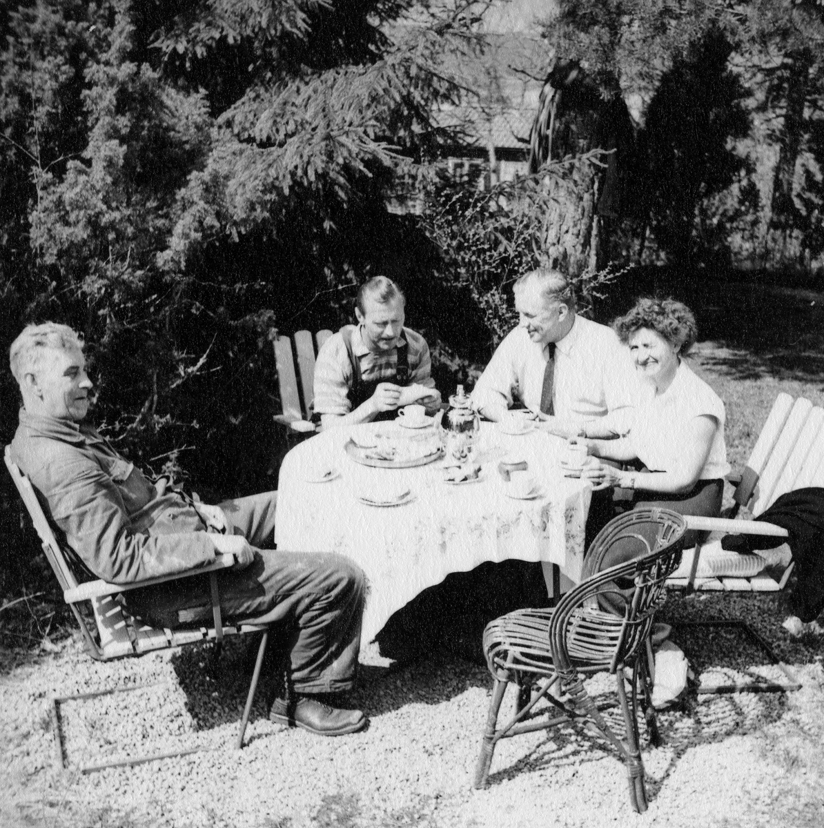 Tre män och en kvinna fikar i en trädgård.

Från vänster: Algot Johansson, Rådman, Erik Andersson och Maja Larsson.
