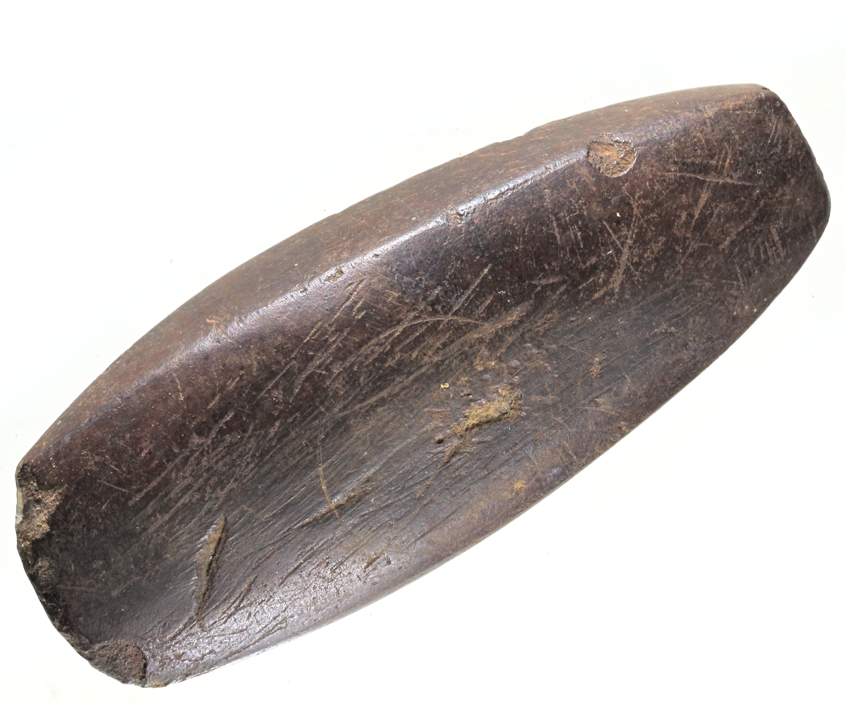 Tykknakket øks av lys grå flint, opprinnelig muligens av typen Erik Hinsch: B.M.Å. 1954, Hist. -ant. rekke, nr. 1, fig. 74. Men den ene bredsiden er avslått på langs og eggen sterkt oppskjerpet, men ikke slipt på nytt. 
