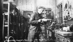 Tre menn i arbeid i reperasjonsverkstedet for malmbiler, 193
